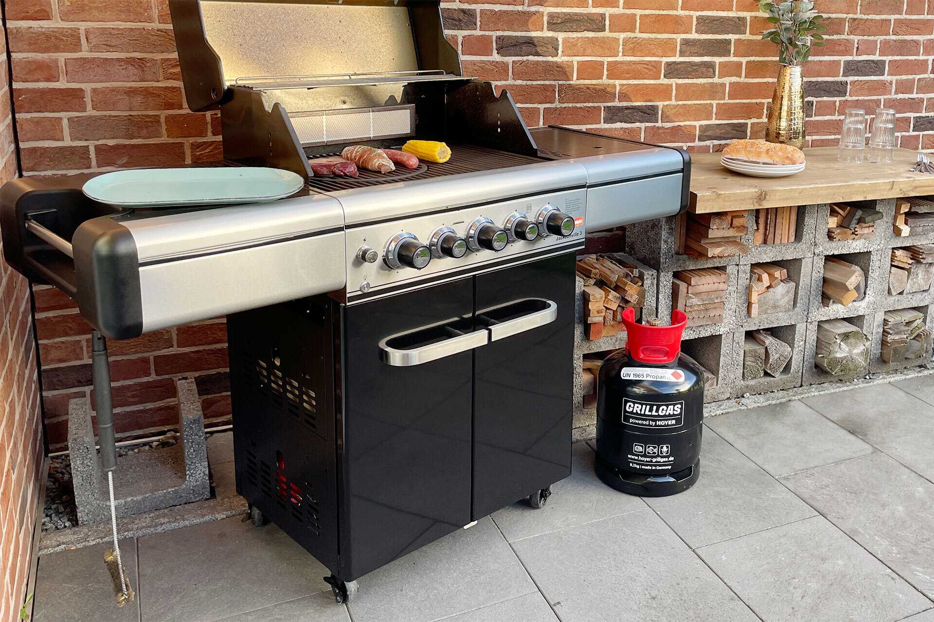 Gasgrill mit schwarzer Hoyer Grillgasflaschen rechts daneben