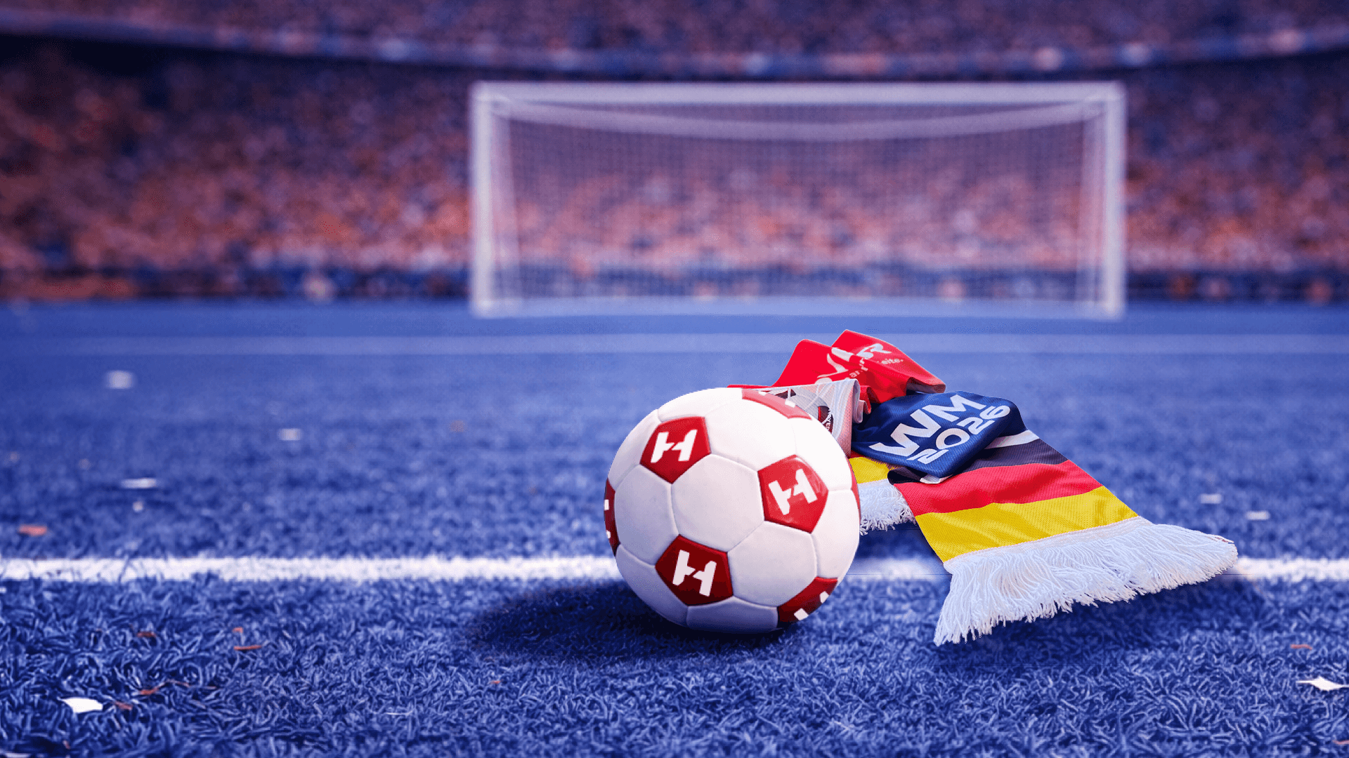 Fußball mit Hoyer Logo und Fanartikeln auf einem blauen Rasen im Stadion